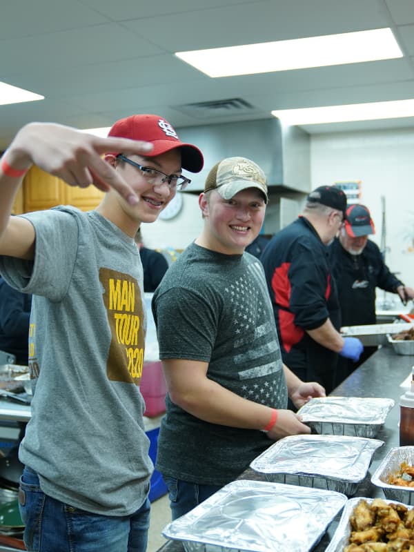 Smiling Missionary Kids Serving Food at Mens Event