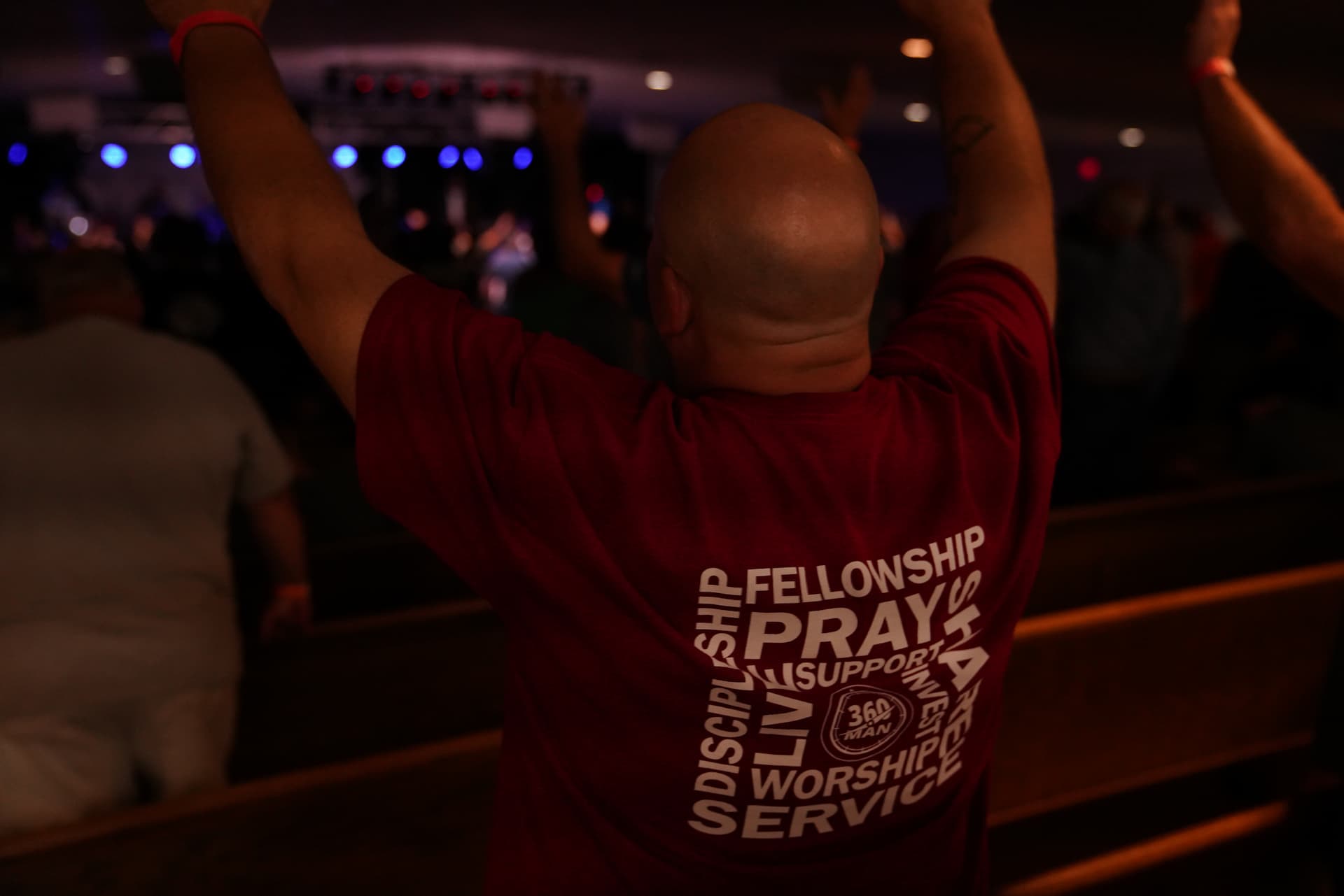 360 Man in red shirt with arms raised worshipping God